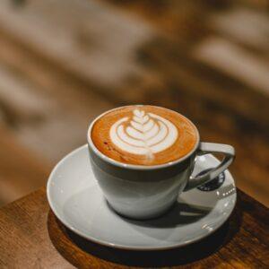 white ceramic cup with saucer on brown wooden table